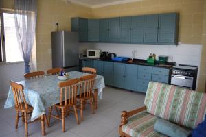 a kitchen with a table and chairs and a kitchen with blue cabinets at Seaview 2-bedroom Apartment in Xlendi in Xlendi