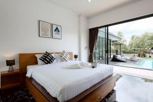 a bedroom with a large bed and a swimming pool at Onyx Stay Pool Villa @Pranburi in Ban Nong Sua
