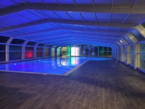 a swimming pool in a large room with blue lighting at Agriturismo Ariston ONC 1484 in Sabaudia