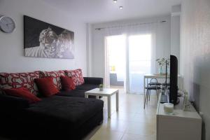 a living room with a couch and a television at South Coast Apartment in Puertito de Güímar