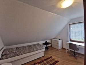 1 dormitorio con cama, escritorio y ventana en Domek na Niedźwiedziarce, en Zawoja