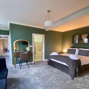 een slaapkamer met een bed, een bureau en een spiegel bij The Spa Hotel in Saltburn-by-the-Sea