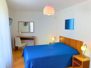 um quarto com uma cama azul e uma secretária em Casas d Aldeia Turismo Rural em Mangualde