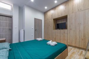 um quarto com uma cama verde e uma televisão na parede em Renovated 2BD house close to Pireus port em Piraeus