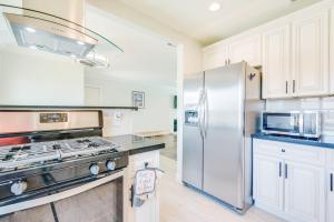 a kitchen with white cabinets and a stainless steel refrigerator at Bright & Airy Pool-Spa Oasis Home-Dogs Welcome! City of Palm Springs # 4243 in Palm Springs