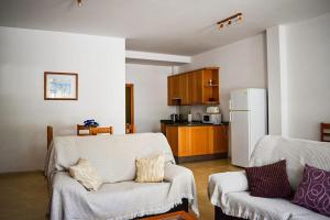 sala de estar con 2 sillas y nevera en Apartamento Maria,Bahía de Alcudia en Alcúdia