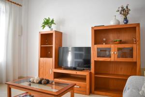 una sala de estar con un centro de entretenimiento con TV de pantalla plana en Apartamento Maria,Bahía de Alcudia en Alcúdia