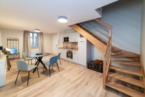 cocina y comedor con escalera, mesa y sillas en Les coursives appartements en Mâcon