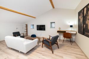 Les coursives appartements في ماكون: غرفة معيشة مع أريكة بيضاء وكراسي