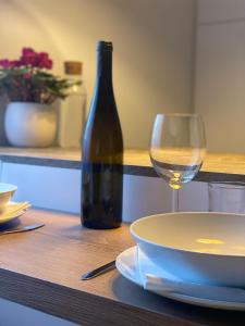 einen Tisch mit einem Teller und einem Glas Wein in der Unterkunft Ansitz von Wohlgemuth in Salurn