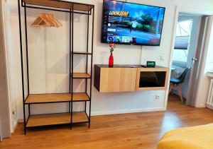Habitación con TV en la pared y estante en Living-Life, Klinik & Messe vor Ort, Wlan, Netflix, en Essen
