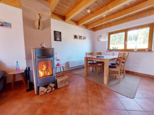 a living room with a fireplace and a dining table at Casa Cubana - Schönes und komfortables Ferienhaus am Waldrand in Lechbruck