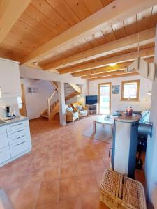 a large kitchen and living room with wooden ceilings at Casa Cubana - Schönes und komfortables Ferienhaus am Waldrand in Lechbruck