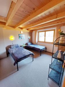 a bedroom with two beds and a wooden ceiling at Casa Cubana - Schönes und komfortables Ferienhaus am Waldrand in Lechbruck