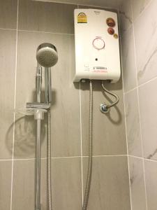 a shower in a bathroom with a hair dryer at Apple Beach ChaAum in Cha Am