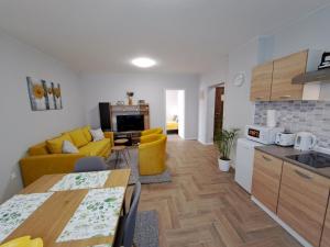 a kitchen and a living room with a yellow couch at Apartments Manna Palic in Palić