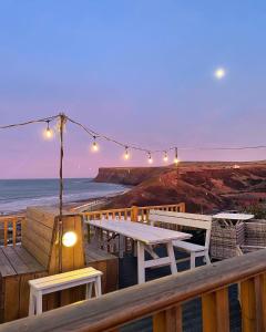 a wooden deck with a table and chairs and the ocean at The Spa Hotel in Saltburn-by-the-Sea