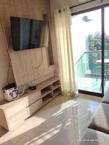 a living room with a flat screen tv on a wall at Apple Beach ChaAum in Cha Am