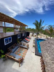 a resort with a swimming pool and a patio with chairs at Jambiani Backpackers Hostel in Jambiani
