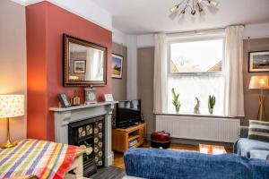 a living room with a fireplace and a tv at Spacious Charming Cottage near Lake and Sea in Hornsea