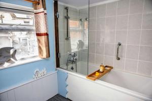 a bathroom with a bath tub and a sink at Spacious Charming Cottage near Lake and Sea in Hornsea