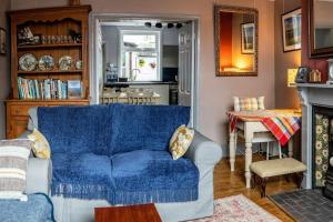 a living room with a blue couch and a table at Spacious Charming Cottage near Lake and Sea in Hornsea