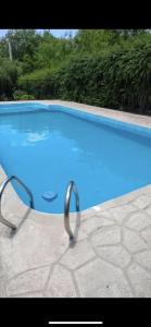 ein großer blauer Pool mit Metallgeländer um ihn herum in der Unterkunft Casita de las sierras in Cordoba