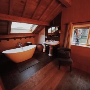 baño con bañera grande y lavamanos en Le verger d' Adèle, en Vielsalm
