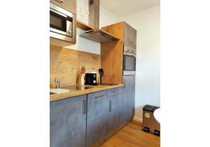 a small kitchen with a sink and a microwave at Living-Life, Klinik & Messe vor Ort, Wlan, Netflix in Essen