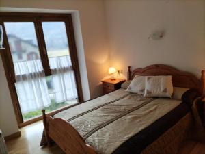 a bedroom with a bed and a large window at Apartamento en Esterri Visita Aiguestortes in Esterri d'Àneu