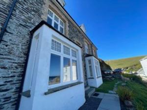 a brick house with two windows and a door at Folly 1, Port Isaac Bay Holidays in Port Isaac