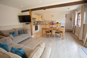 a living room and kitchen with a table and a couch at Newclose Farm Cottages in Yarmouth