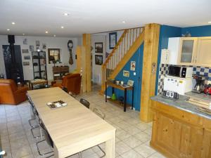 a kitchen with a wooden table in a room at La ferme aux chats in Formigny