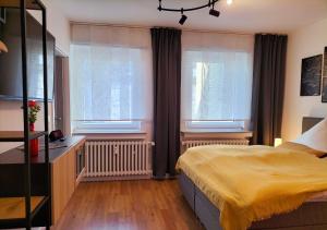 1 dormitorio con 1 cama y 2 ventanas en Living-Life, Klinik & Messe vor Ort, Wlan, Netflix, en Essen