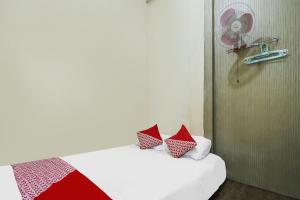 una camera da letto con un letto con cuscini rossi e bianchi di SPOT ON 92053 Bagus Stay a Tanjung Pinang