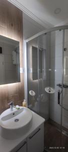 a bathroom with a sink and a glass shower at Cozy place in Trebinje