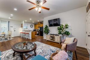a living room with a ceiling fan and a table at Little Blue House on Lonnie Lane in Houston