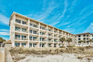 a large hotel on the beach with a blue sky at Windancer 211 in Destin
