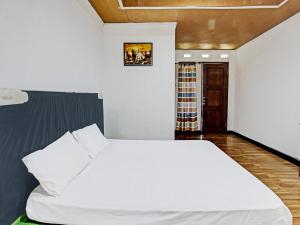 龍目島的住宿－OYO 92090 Panorama Rinjani Lodge，卧室配有一张白色大床