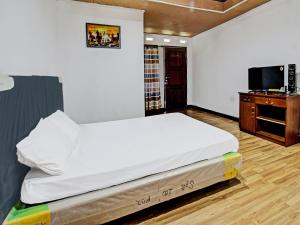a bedroom with a large bed and a desk at OYO 92090 Panorama Rinjani Lodge in Labuan Lombok