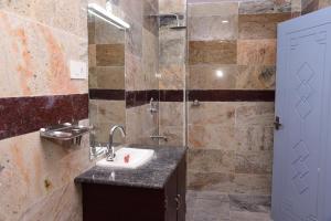 a bathroom with a sink and a shower at Thangam Residency in Kāraikkudi