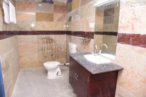 a bathroom with a sink and a toilet in it at Thangam Residency in Kāraikkudi