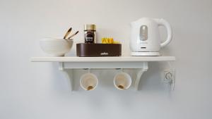 a shelf on a wall with a coffee maker and a mixer at Motel Arctic Wind in Vogar