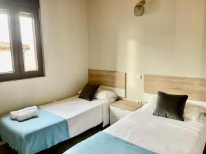 a room with two beds and a window at Casa La Cantina in La Horra