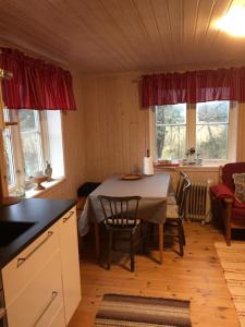uma cozinha com mesa e cadeiras num quarto em Stuga vid viltåker nära norska gränsen em Strömstad