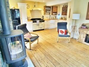 a kitchen with a stove and two chairs and a fireplace at Sunny Dale in Niton
