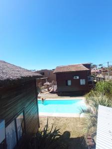 a house with a swimming pool next to a building at El Diablo en Paz in Punta Del Diablo