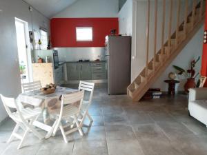 a kitchen with a table and chairs and a refrigerator at Villa SUNESIS Lamentin in Lamentin