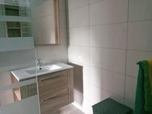 a white bathroom with a sink and a mirror at Villa SUNESIS Lamentin in Lamentin