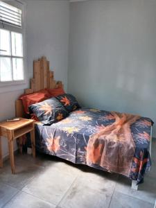 een slaapkamer met een bed en een houten tafel bij Villa SUNESIS Lamentin in Lamentin